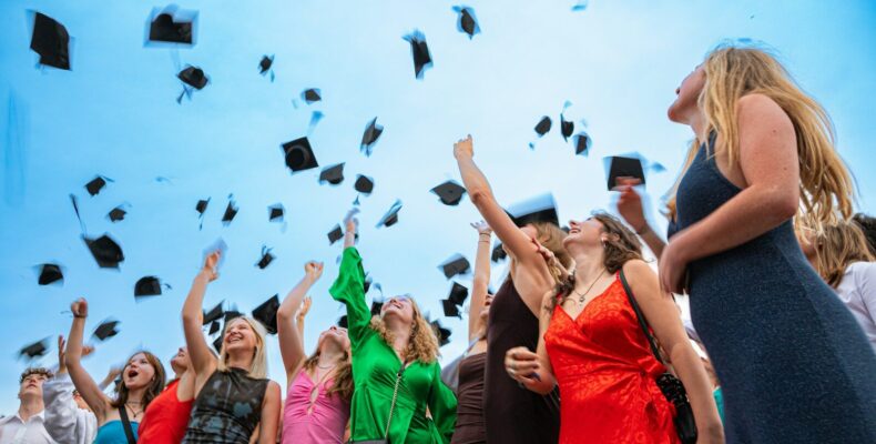 Graduates are throwing their caps into the air.